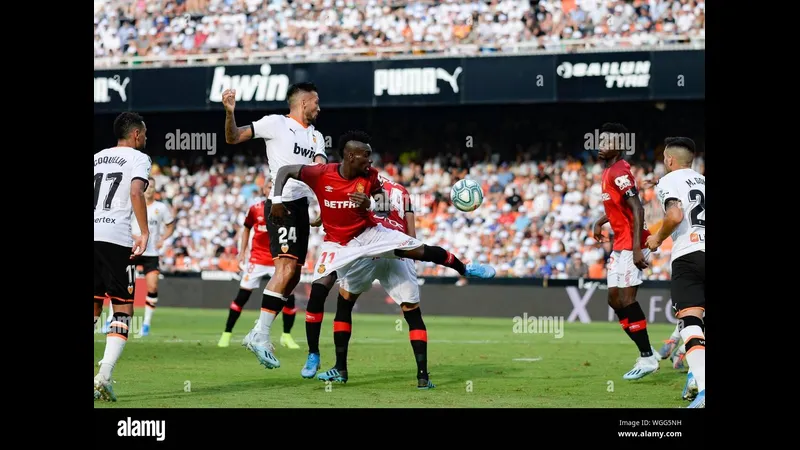 Cầu thủ của Valencia vượt qua hậu vệ của Mallorca trong trận đấu