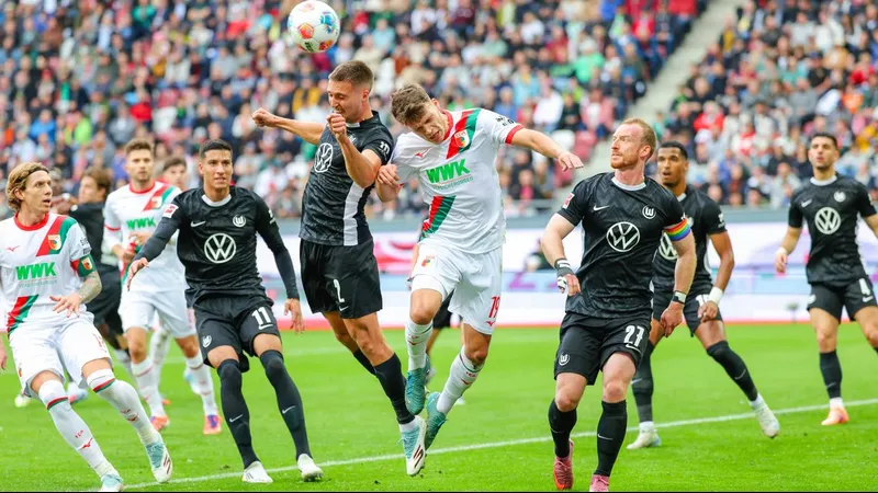 Cầu thủ của Wolfsburg và Augsburg tranh chấp bóng trên sân cỏ Cầu thủ của Wolfsburg và Augsburg tranh chấp bóng trên sân cỏ